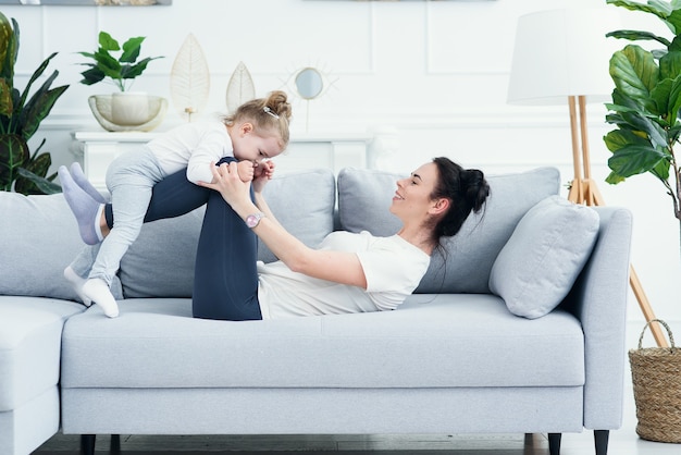 Mamma e figlia che ridono insieme sdraiato sul divano.