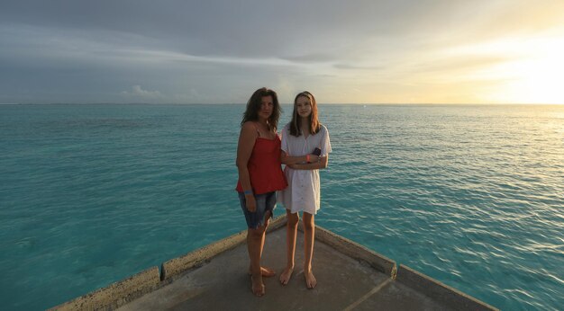 mamma e figlia che scattano foto sull'oceano