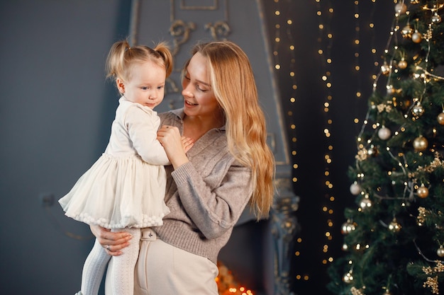 Mamma e figlia che si abbracciano vicino all'albero di Natale