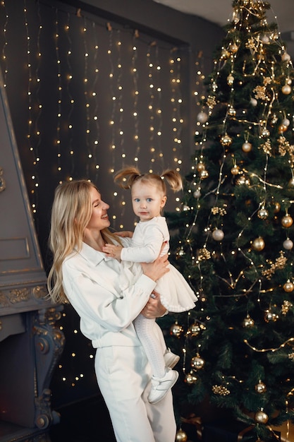 Mamma e figlia che si abbracciano vicino all'albero di Natale