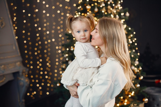 Mamma e figlia che si abbracciano vicino all'albero di Natale