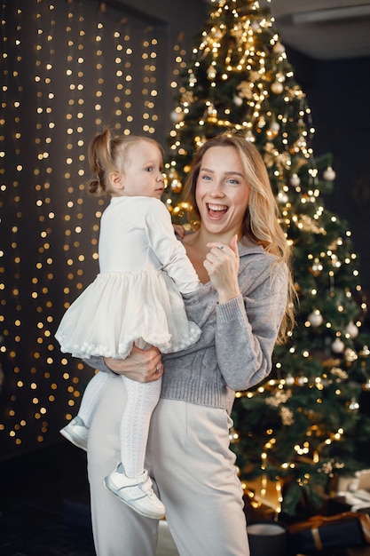 Mamma e figlia che si abbracciano vicino all'albero di Natale