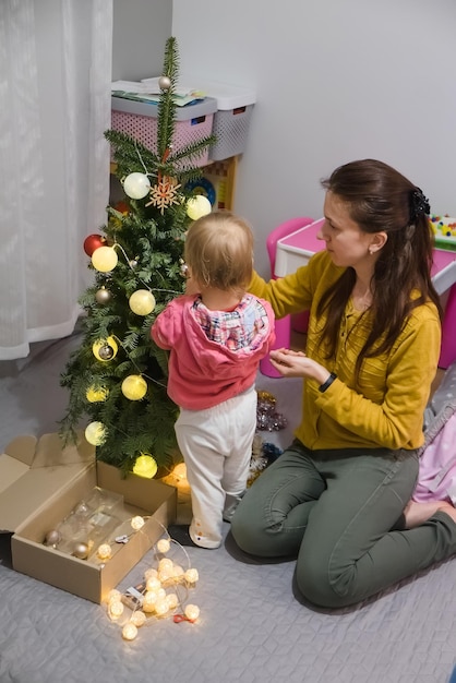 Mamma e figlia decorano l'albero di Natale a casa