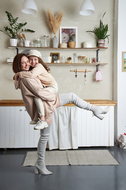 Mamma e figlia di moda di bellezza. Servizio fotografico di famiglia, gioia e emozioni divertenti. Donna e una ragazza Abbraccio