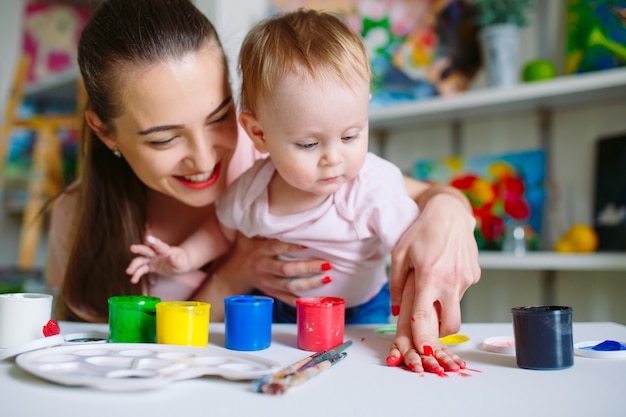 Mamma e figlia dipingono su tela alla scuola di disegno.