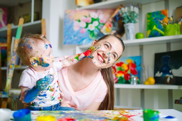 Mamma e figlia dipingono su tela alla scuola di disegno.