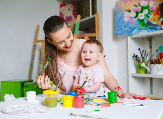 Mamma e figlia dipingono su tela alla scuola di disegno.