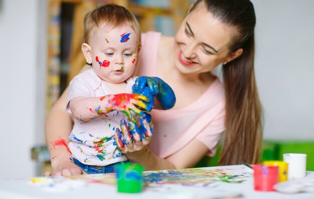 Mamma e figlia dipingono su tela alla scuola di disegno.