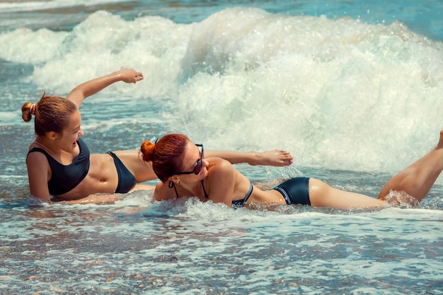 Mamma e figlia giacciono in riva al mare