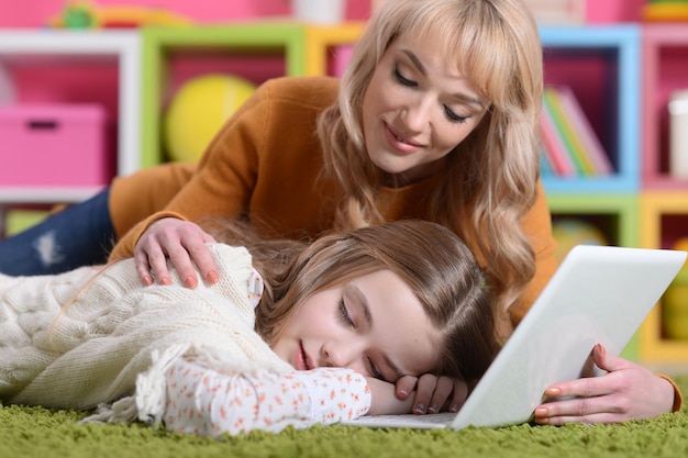 Mamma e figlia giacciono sul tappeto