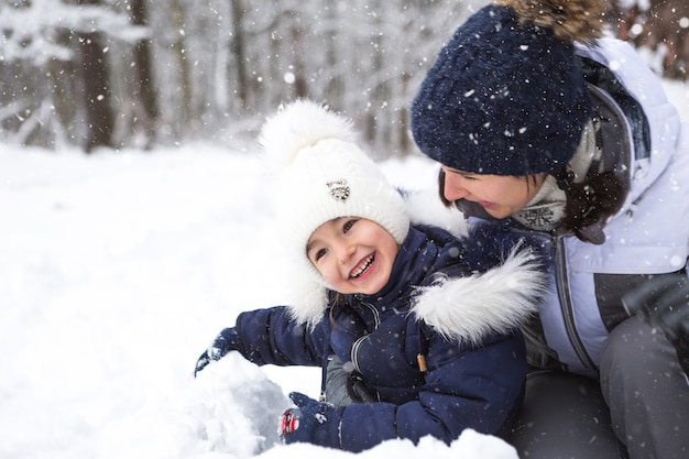 Mamma e figlia giocano a giochi di neve, costruiscono una fortezza, fanno palle di neve