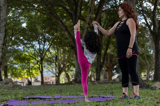 Mamma e figlia latinoamericane si divertono nel parco facendo esercizi di bilanciamento insieme