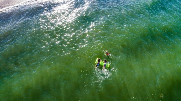 Mamma e figlia si divertono tra le onde del surf sul mare. Momenti felici con i bambini.