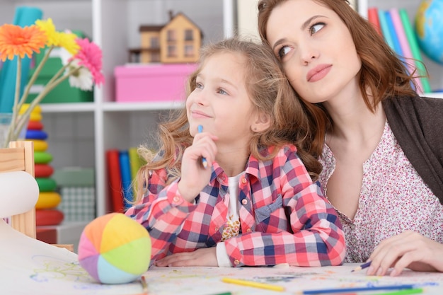 Mamma e figlia stanno giocando al tavolo