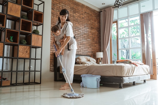 Mamma e figlia stanno lavando il pavimento della casa