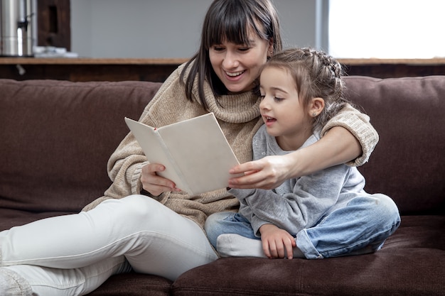 Mamma e figlia trascorrono del tempo insieme leggendo un libro. Il concetto di sviluppo dei bambini e tempo di qualità.