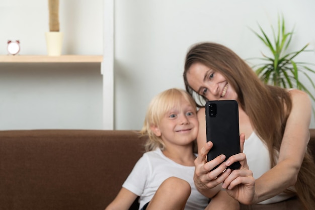 Mamma e figlio carini si fanno selfie a casa Mamma e figlio scattano foto su uno smartphone