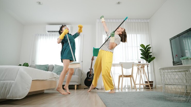 Foto mamma e figlio caucasici che fanno le faccende domestiche insieme e ballano alla musica pedagogia