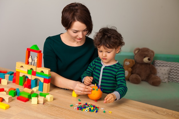 Mamma e figlio che giocano insieme ai mattoni di legno