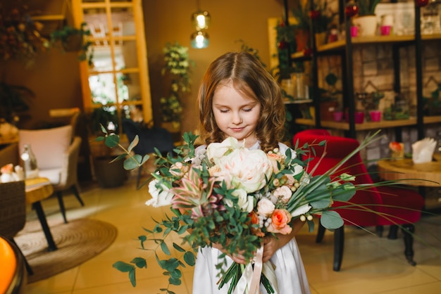 Mamma e figlio con fiori in caffe. Il figlio dà i fiori alla madre. famiglia carina. Giornata internazionale della donna, 8 marzo celebrativa