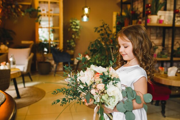 Mamma e figlio con fiori in caffe. Il figlio dà i fiori alla madre. famiglia carina. Giornata internazionale della donna, 8 marzo celebrativa