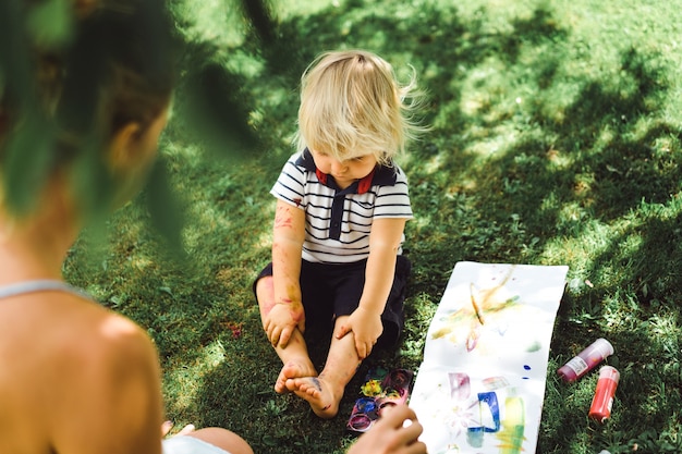 Mamma e figlio dipingono sulla natura.