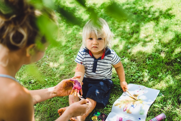 Mamma e figlio dipingono sulla natura.