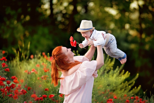 Mamma e figlio giocano in un campo di papaveri in fiore