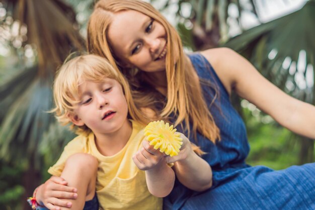 Mamma e figlio hanno fatto un picnic nel parco. Mangia frutta sana: mango, ananas e melone. I bambini mangiano cibo sano.