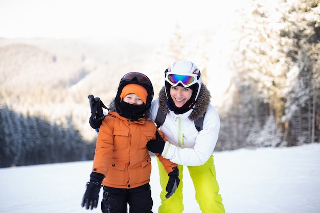 Mamma e figlio in attrezzatura da sci sulla pista da sci