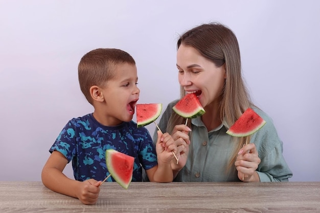 Mamma e figlio mangiano felicemente l'anguria