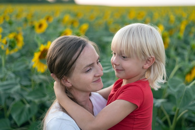 Mamma e figlio si guardano nel campo di girasoli