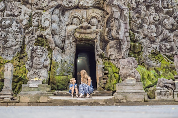 Mamma e figlio sono turisti nel vecchio tempio indù di Goa Gajah vicino a Ubud sull'isola di Bali, Indonesia. Viaggia a Bali con il concetto di bambini