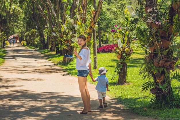 Mamma e figlio stanno camminando nel parco tropicale