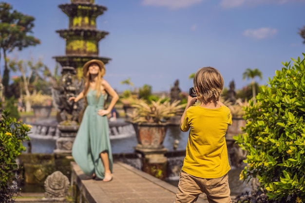 Mamma e figlio turisti a Taman Tirtagangga Water Palace Parco acquatico Bali Indonesia Viaggiare con i bambini Concetto Luogo adatto ai bambini