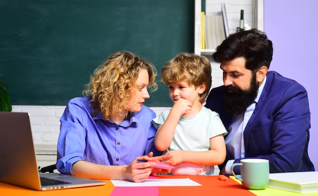 Mamma e papà aiutano l'educazione dell'allievo del bambino ragazzo felice famiglia scolarizzazione matematica insieme per la prima volta