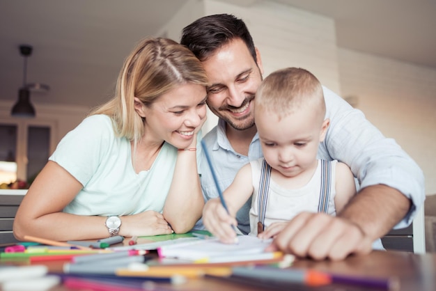 Mamma e papà con bambino che disegnano a casa