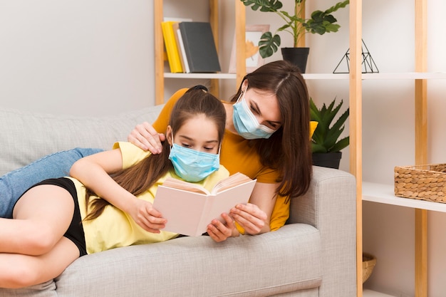 Mamma e ragazza con lettura maschera