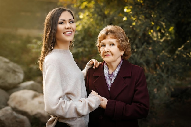 Mamma felice con la figlia che si tiene per mano all'aperto