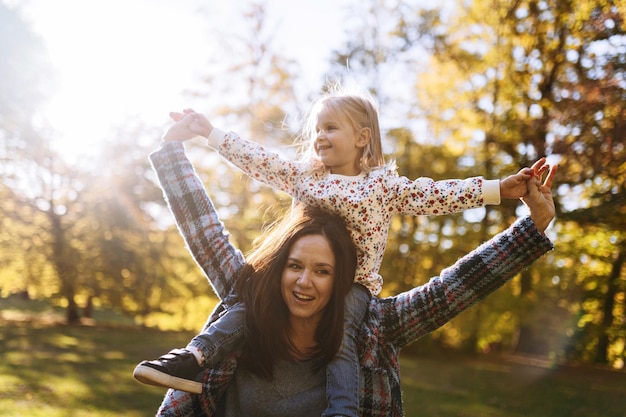 Mamma felice con la piccola figlia nella ricreazione all'aperto del parco di autunno Mamma e figlia