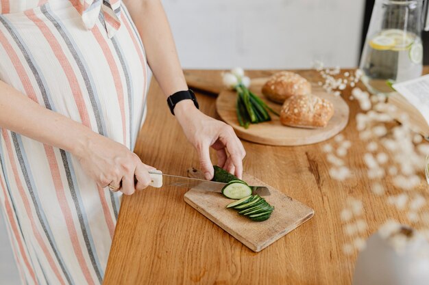 Mamma in attesa che taglia le zucchine in cucina