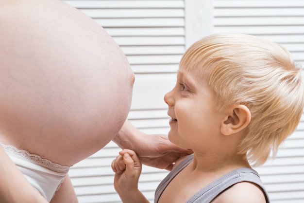 Mamma incinta e figlio maggiore. Preparazione alla gravidanza e concetto di aspettativa.