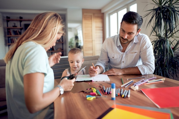 Mamma papà e figlio disegnano in soggiorno