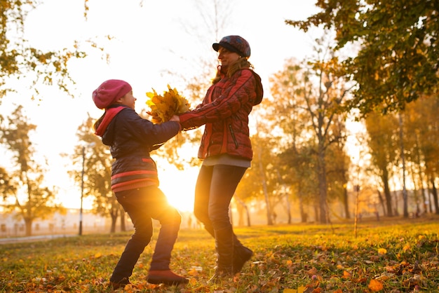 Mamma positiva e ragazza allegra rimbalza mentre si cammina nel parco