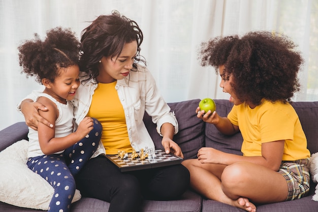 Mamma single si prende cura di lei, insegna ai suoi figli ad essere geniali e alle bambine intelligenti che imparano a giocare a scacchi mangiando frutta per essere sani