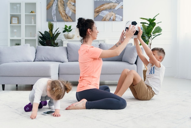 Mamma sportiva con figlio che fa allenamento mattutino a casa. Mamma e figlio fanno esercizi insieme, concetto di stile di vita familiare sano