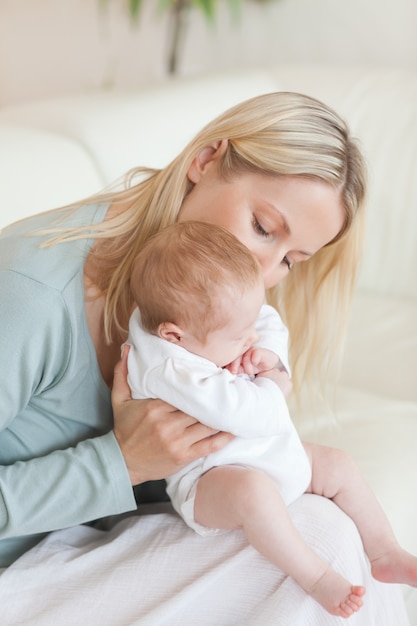 Mamma sul divano che tiene il suo bambino