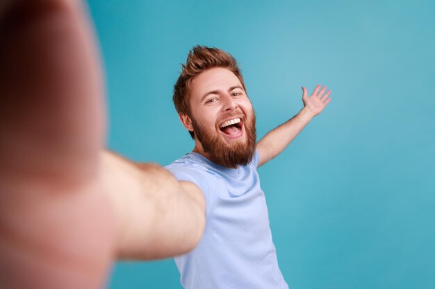 Man blogger POV point of view of photo welcoming happily raised arm expressing happiness