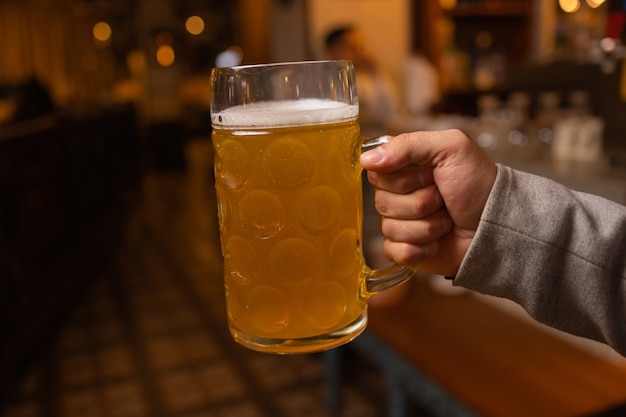 Man Holding Cold Beer Glass con la sua mano. Birra Lager Fredda Rinfrescante.