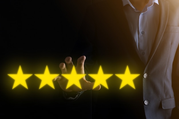 Man mano che mostra su cinque stelle eccellente rating.pointing simbolo a cinque stelle per aumentare la valutazione dell'azienda.